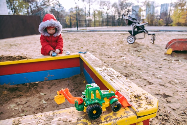 Il bambino gioca con le macchine nel parco giochi