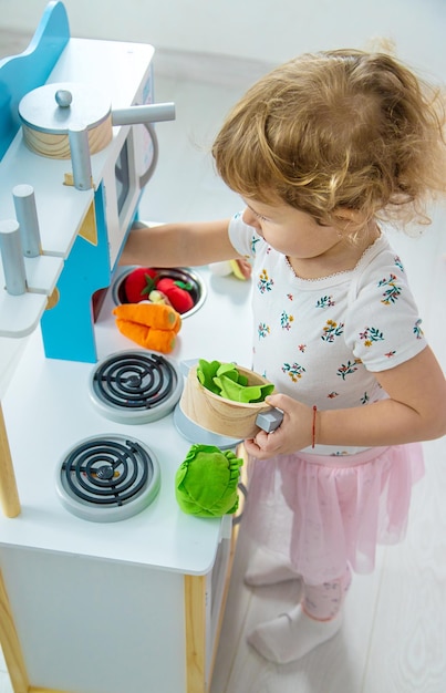 Il bambino gioca in cucina e cucina Focus selettivo