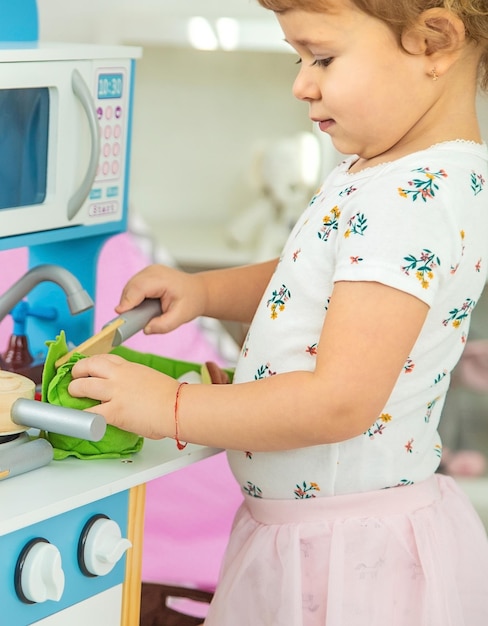 Il bambino gioca in cucina e cucina Focus selettivo