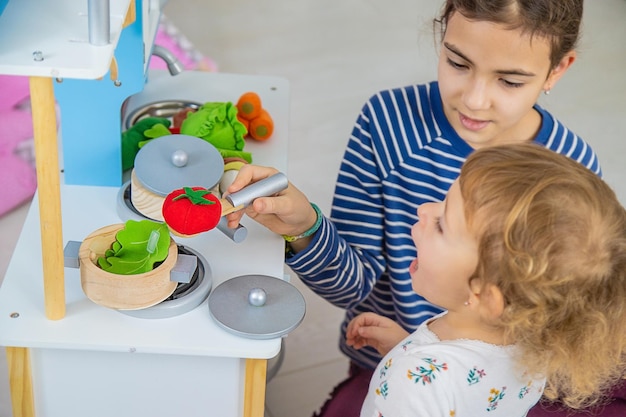 Il bambino gioca in cucina e cucina Focus selettivo