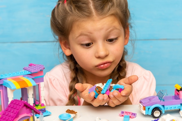 Il bambino guarda molti dettagli del costruttore su uno sfondo azzurro.