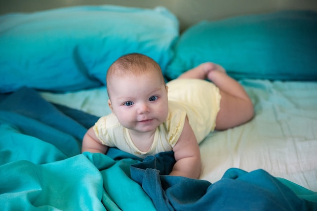 il bambino ha 5 mesi sdraiato su un grande letto a pancia in giù