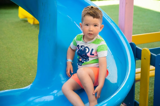 Il bambino ha paura di rotolare giù dallo scivolo per bambini