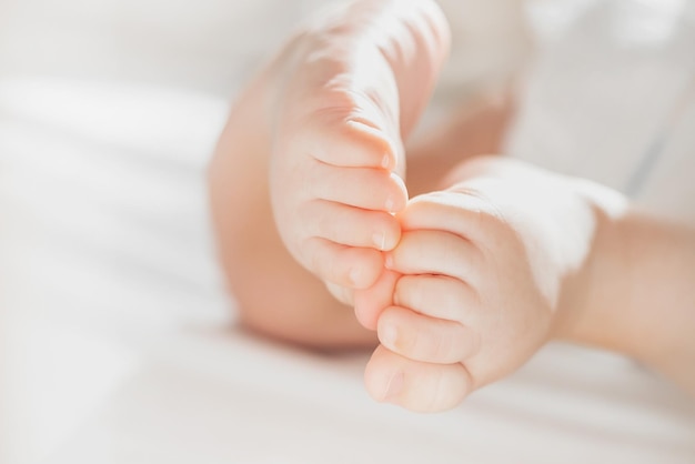 Il bambino in un pannolino si trova su uno spazio bianco della copia di vista superiore del letto