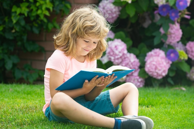 Il bambino legge il libro scuola per bambini e educazione all'aria aperta natura e parco apprendimento precoce estate all'aperto imparare