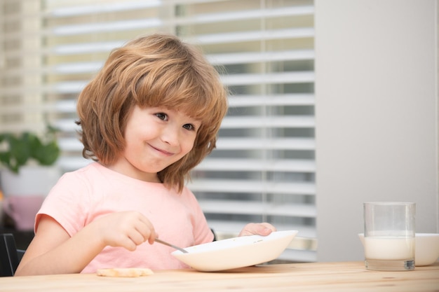 Il bambino mangia cibo sano a casa il bambino mangia la zuppa con il cucchiaio