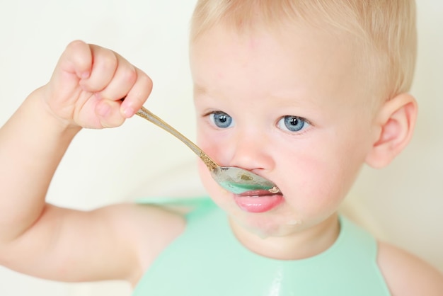 il bambino mangia con un cucchiaio e impara da solo