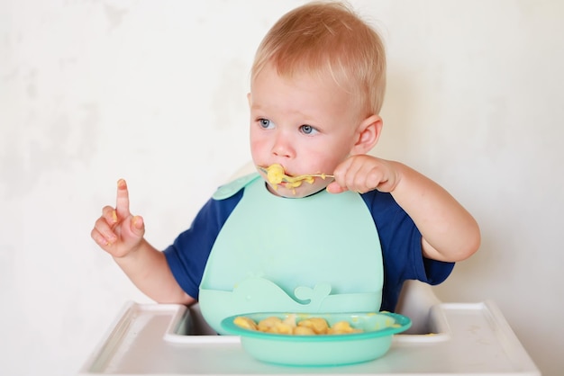 il bambino mangia con un cucchiaio e impara da solo