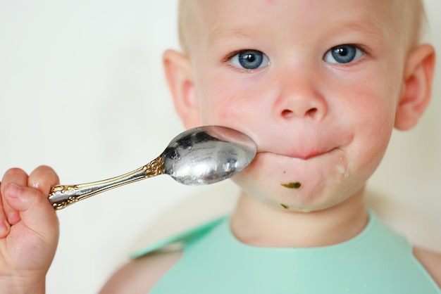 il bambino mangia con un cucchiaio e impara da solo