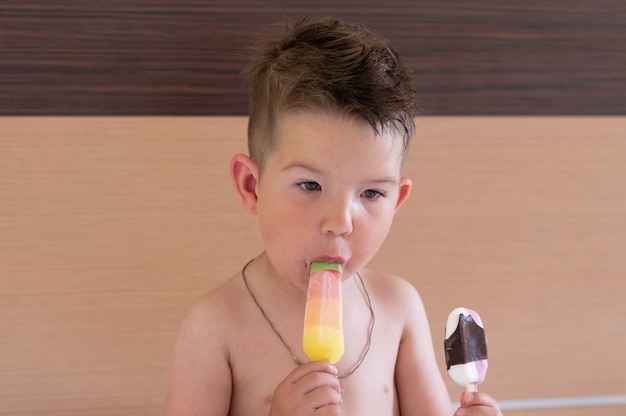 Il bambino mangia due gelati.