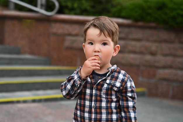 Il bambino mangia il gelato per strada