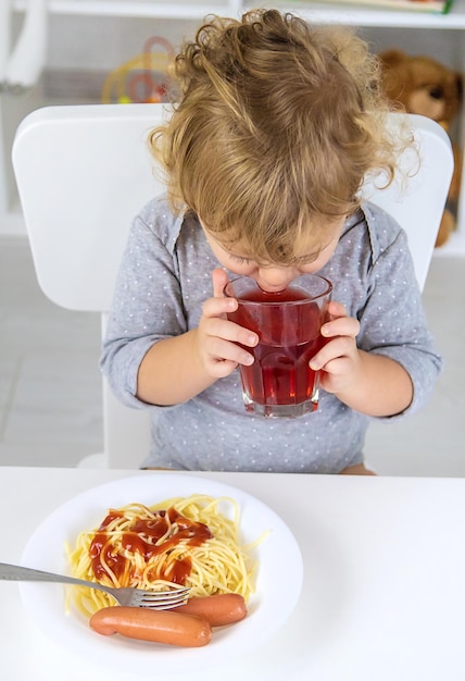 Il bambino mangia il pranzo degli spaghetti Fuoco selettivo