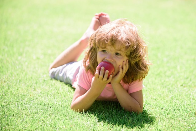 Il bambino mangia la nutrizione sana del ragazzo della mela per l'ora di pranzo dello spuntino della frutta dei bambini