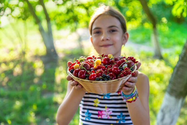 Il bambino mangia le bacche nel giardino Messa a fuoco selettiva