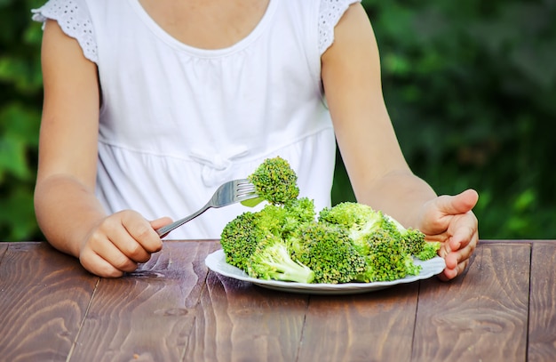 Il bambino mangia le verdure Foto d&#39;estate Messa a fuoco selettiva