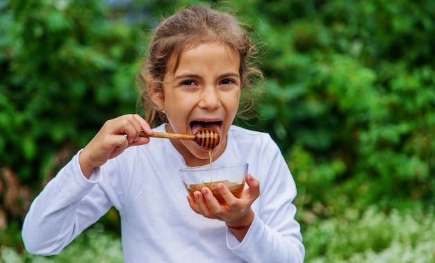 Il bambino mangia miele e mele. Messa a fuoco selettiva.