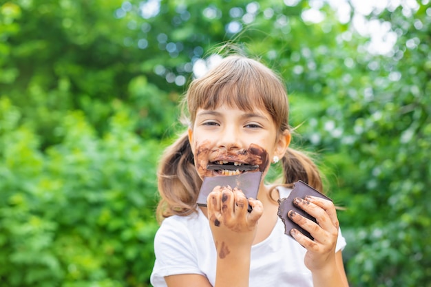 Il bambino mangia una barretta di cioccolato.