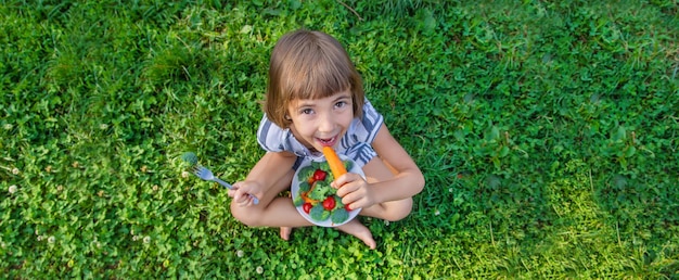 Il bambino mangia verdure broccoli e carote Messa a fuoco selettiva