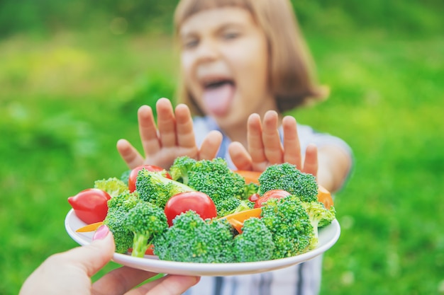 Il bambino mangia verdure broccoli e carote