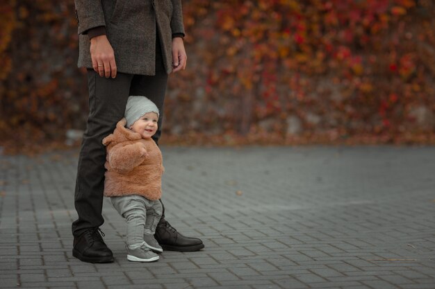 Il bambino muove i primi passi con l'aiuto del padre.
