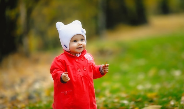 Il bambino nel fogliame autunnale muove i primi passi