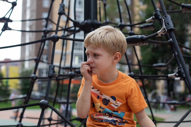 Il bambino nel parco giochi è sconvolto. È triste, sta per piangere