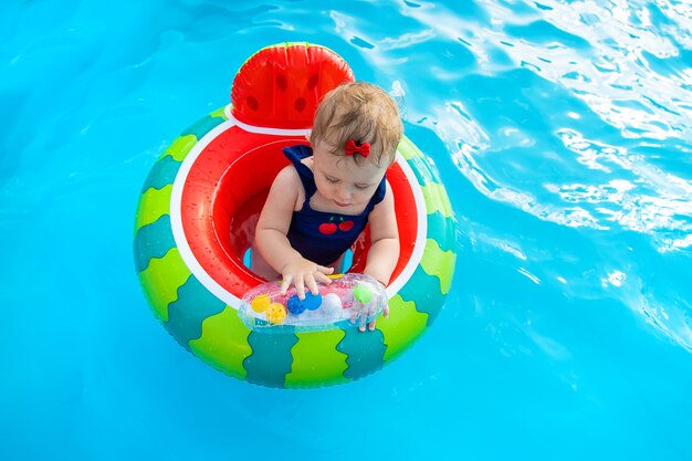 Il bambino nuota in cerchio in piscina. Messa a fuoco selettiva.