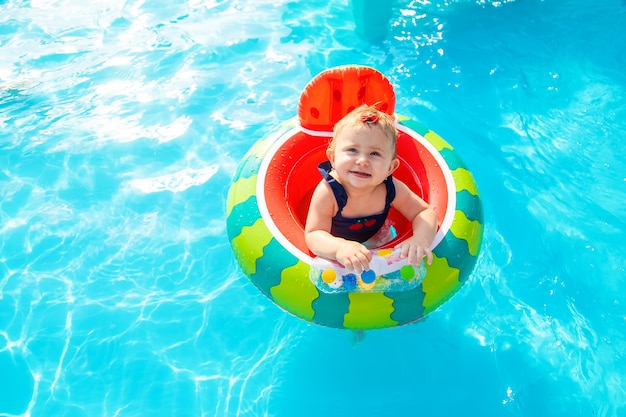 Il bambino nuota in cerchio in piscina. Messa a fuoco selettiva.