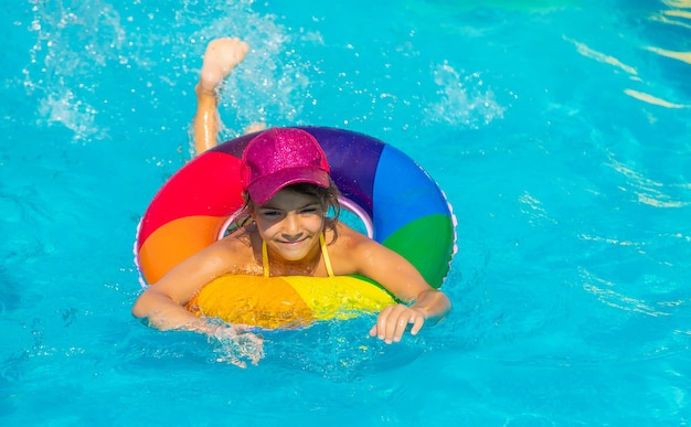 Il bambino nuota in piscina in cerchio. Messa a fuoco selettiva.