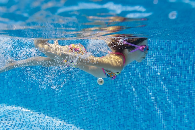 Il bambino nuota in piscina sott'acqua