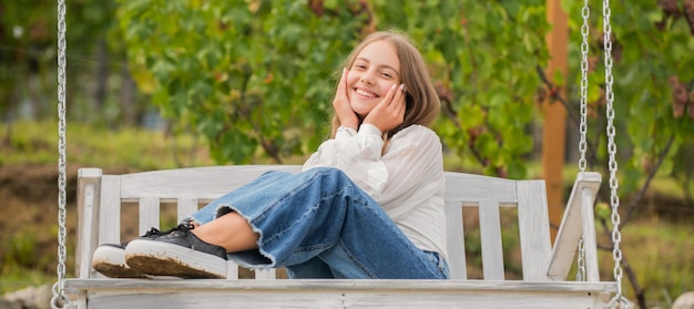 il bambino positivo si siede sull'altalena all'aperto, la felicità.