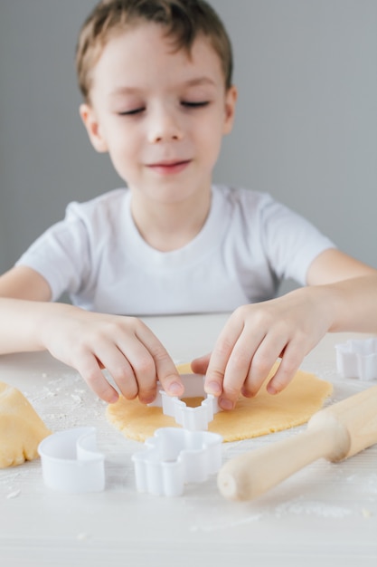 Il bambino prepara biscotti natalizi fatti in casa