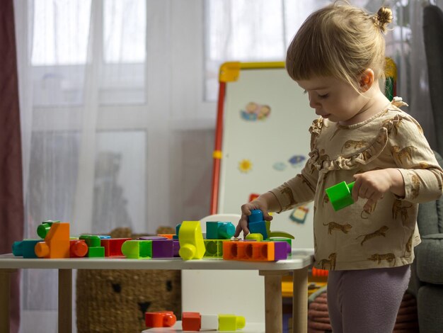 Il bambino raccoglie il designer al tavolo nella stanza dei bambini