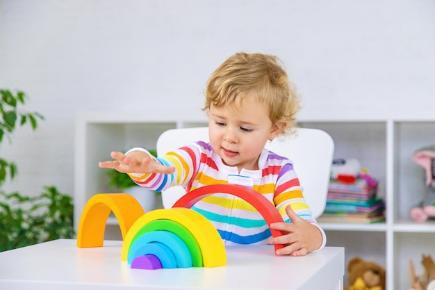 Il bambino raccoglie il fuoco selettivo dell'arcobaleno del costruttore