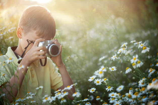 Il bambino scatta una foto nel campo della camomilla