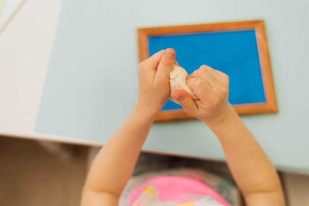 Il bambino scolpisce da pasta di sale su una cornice blu