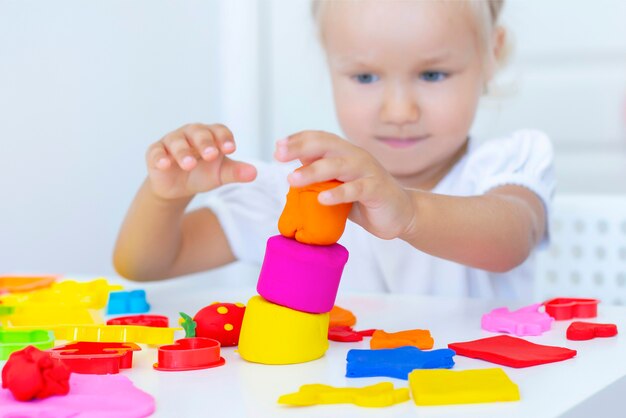 Il bambino scolpisce dalla plastilina colorata