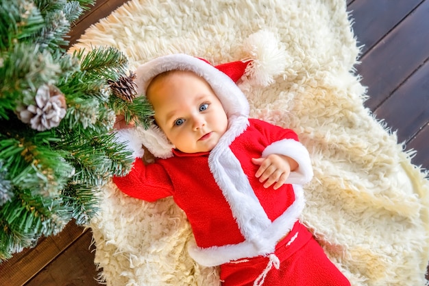 Il bambino si bagna in una bacinella con schiuma e bolle di sapone su sfondo bianco