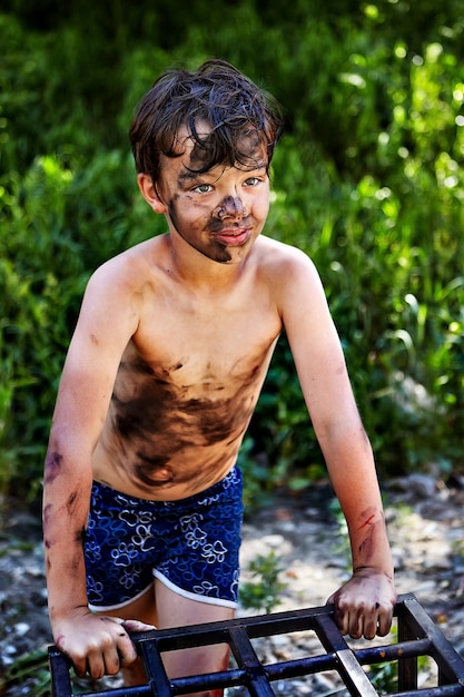 Il bambino si è sporcato durante le vacanze estive in campagna.