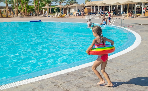 Il bambino si tuffa in piscina. Messa a fuoco selettiva.