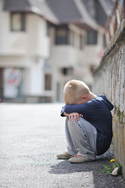 il bambino solo triste e infelice piange e ha problemi di emozione per strada