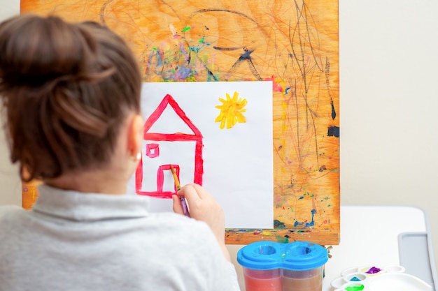 Il bambino sta disegnando la casa.