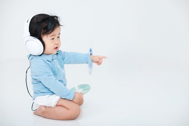 il bambino sta giocando felicemente con le sue cuffie su bianco