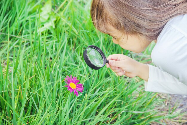 Il bambino sta guardando in una lente d&#39;ingrandimento. Aumentare. messa a fuoco selettiva.