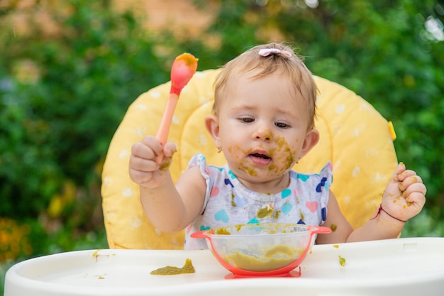 Il bambino sta mangiando la purea di verdure. Messa a fuoco selettiva. Bambino.