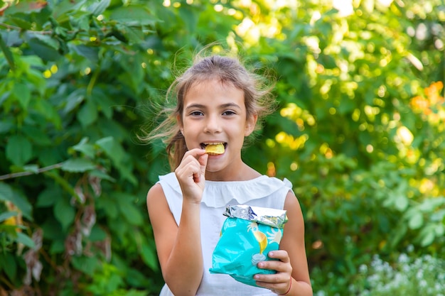 Il bambino sta mangiando patatine. Messa a fuoco selettiva. Ragazzo.