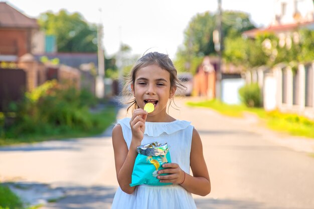 Il bambino sta mangiando patatine. Messa a fuoco selettiva. Ragazzo.