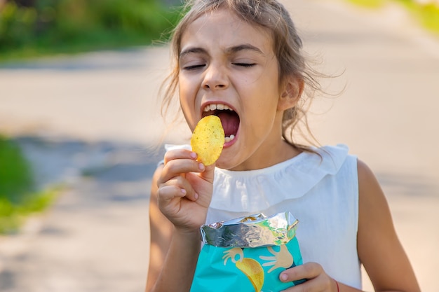 Il bambino sta mangiando patatine. Messa a fuoco selettiva. Ragazzo.