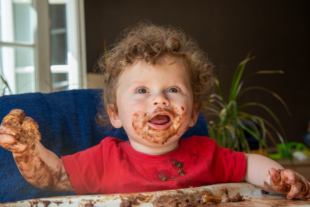 Il bambino sta mangiando una torta al cioccolato
