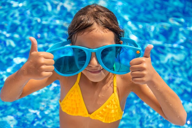 Il bambino sta nuotando in piscina. Messa a fuoco selettiva. Ragazzo.